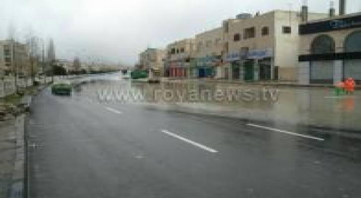 بالصور : الأمطار تغلق منهل تصريف مياه في عمان وكوادر الأمانة تقوم بفتحه