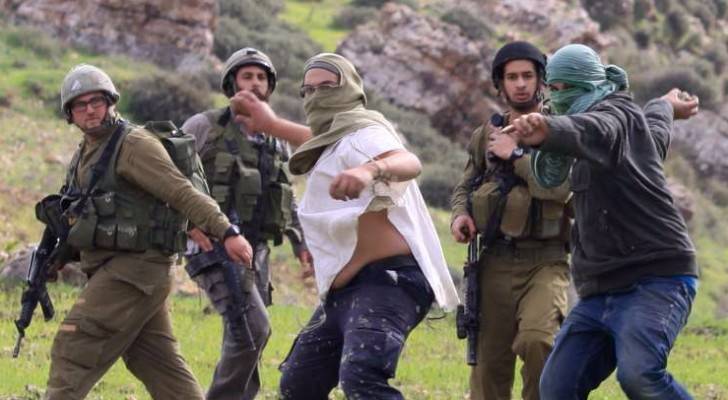 مستوطنون برفقة قوات الاحتلال يرشقون فلسطينيين بالحجارة - أرشيفية