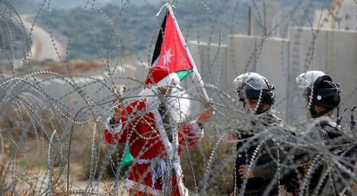 شاب فلسطيني يرفع علم الأردن خلال مظاهرات غرب رام الله 