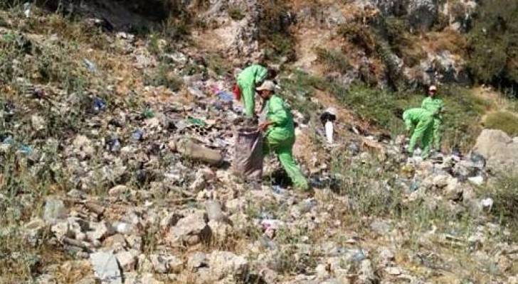 عمال وطن ينظفون احدى المناطق 