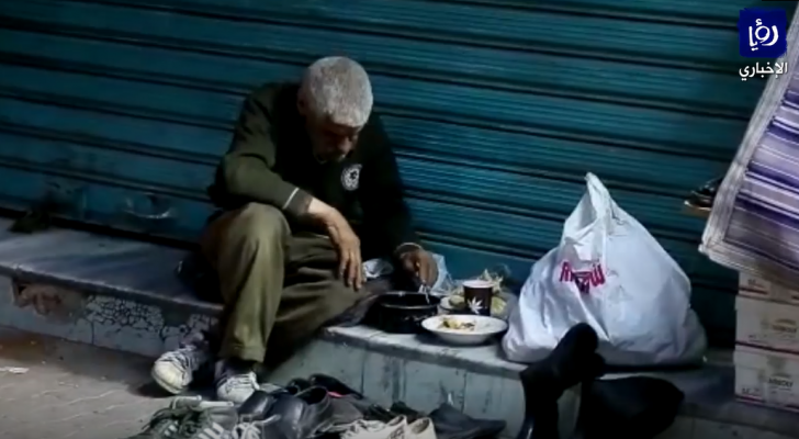 مسن يفطر وحيدا على قارعة الطريق في وسط البلد