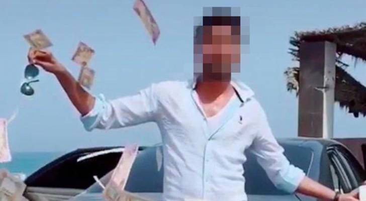 شرطة دبي تقبض على شاب يرمي الأوراق النقدية بالشارع