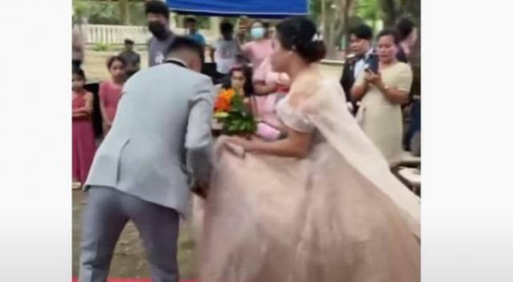 فضيحة الفستان.. رجل يظهر فجأة من أسفل فستان عروس في أثناء حفل الزفاف - فيديو