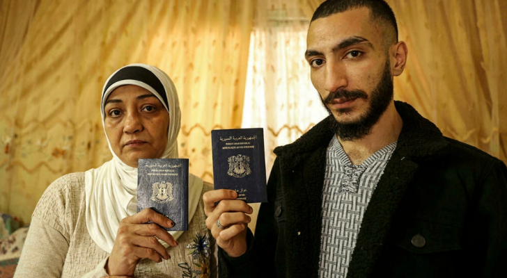 اللاجئان السوريان لينا حسون ونورس ديب يحملان جوازي سفرهما السوريين المنتهيي الصلاحية في غزة - ا ف ب