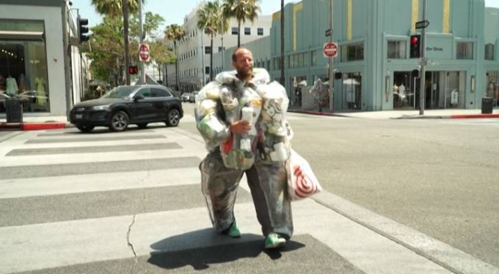 في مشهد غريب.. أمريكي يرتدي القمامة ويجوب الشوارع لمكافحة الاستهلاك المفرط