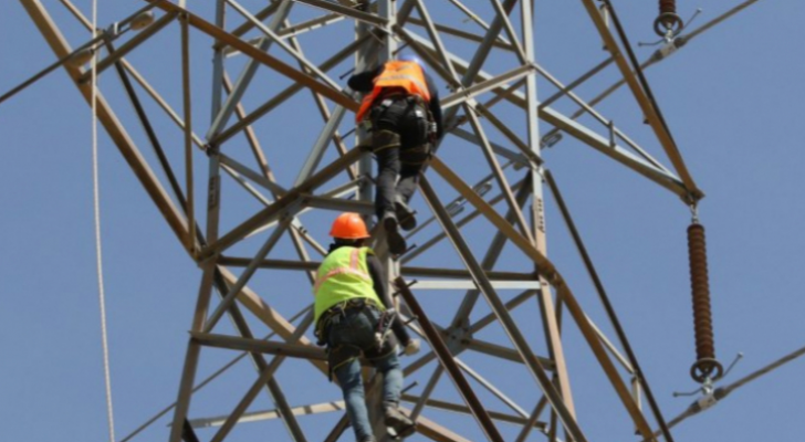 عاملان يجريان صيانة لخطوط الشبكة الكهربائية