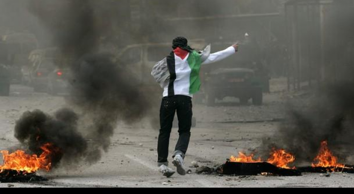 شاب فلسطيني في مواجهة مع مركبات عسكرية تابعة للاحتلال الإسرائيلي
