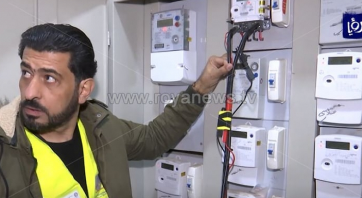 شخص يقف أمام عدادات الكهرباء