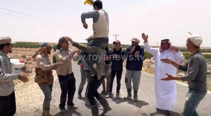 عمال مزارع يلتفون حول صاحب العمل ويحتفلون