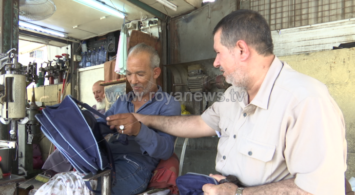 مواطن بجانب صاحب ورشة خياطة
