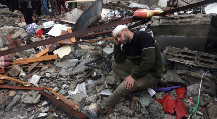 رجل فلسطيني يجلس على أنقاض منزله في غزة