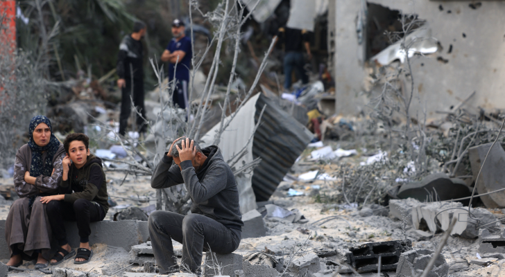عائلة فلسطينية تجلس على ركام منزلها المدمر في غزة