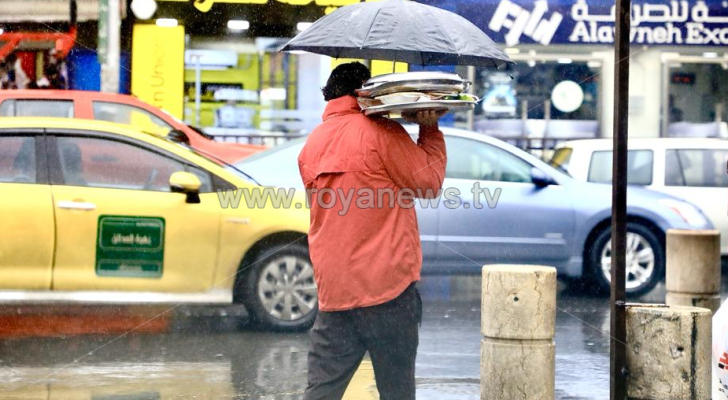 شخص يسير في أحد شوارع العاصمة اثناء هطول الأمطار