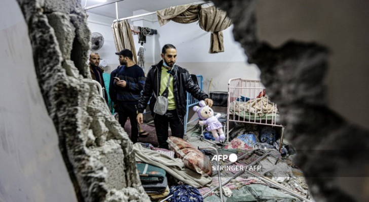 أشخاص يتفقدون الأضرار بعد القصف الإسرائيلي على مستشفى ناصر في خان يونس - AFP