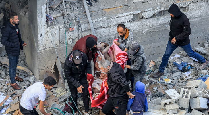 فلسطينيون ينتشلون شهداء في أعقاب غارة للاحتلال على مخيم المغازي - AFP