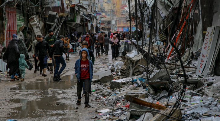 فلسطينيون يسيرون وسط الدمار في قطاع غزة