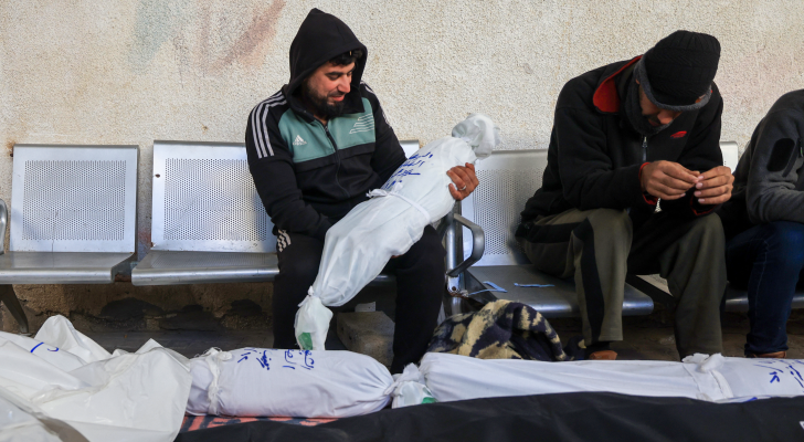 فلسطيني يحمل طفل استشهد جراء عدوان الاحتلال على غزة
