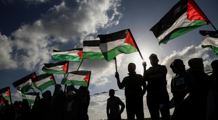 أشخاص يحملون علم فلسطين