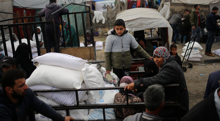 فلسطينون يحملون أكياس طحين