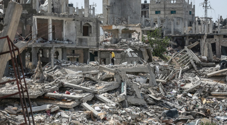 رجل فلسطيني يمشي على أنقاض مبنى في خان يونس بجنوب قطاع غزة