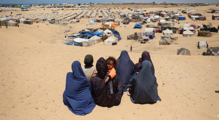 فلسطينيات أمام خيام النزوح في رفح جنوبي قطاع غزة