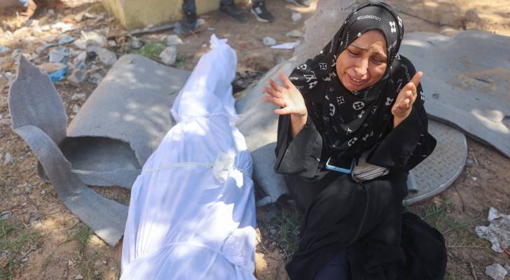 فلسطينية تبكي بجانب جثمان أحد أقاربها الذي استشهد في مجزرة المواصي بقطاع غزة