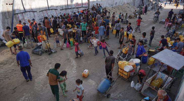 فلسطينيون يتجمعون للحصول على قليل من الماء في خان يونس جنوبي قطاع غزة