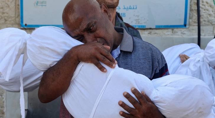 أب يحتضن جثمان نجله الشهيد في غزة "أ ف ب"