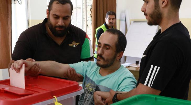 مساعدة مرشح لإدلاء صوته في الانتخابات النيابية
