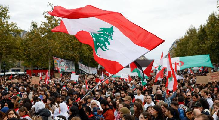 متظاهرون يلوحون بالأعلام اللبنانية والفلسطينية خلال مظاهرة لدعم الشعب اللبناني في باريس