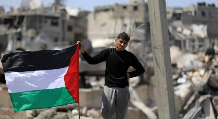 فلسطيني يتمسك بعلم بلاده في قطاع غزة