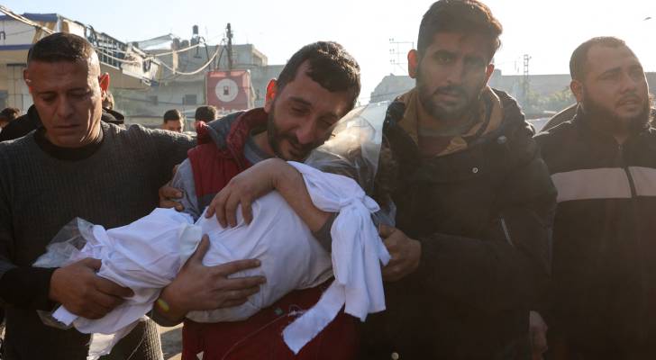 فلسطيني يحمل جثمان نجله الشهيد في غزة