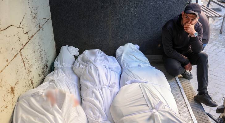 فلسطيني محاط بجثامين في مستشفى الأهلي بغزة