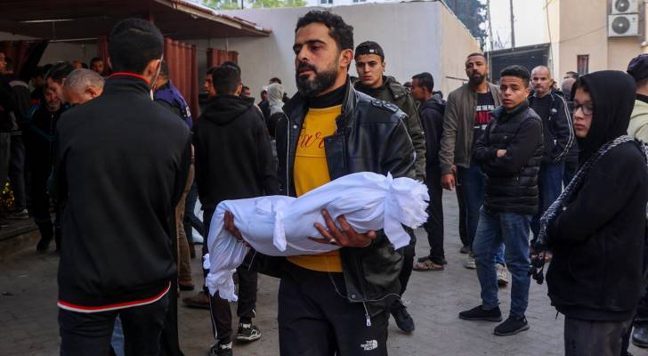 فلسطيني يحمل طفله الشهيد في غزة
