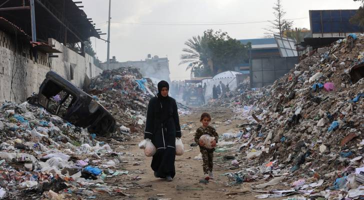 فلسطينية وطفلتها تحصل على القليل من المواد الغذائية في غزة