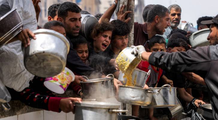 غزيون يستلمون وجبات خيرية من مطبخ في بيت لاهيا شمال قطاع غزة