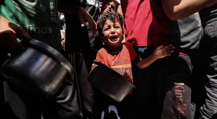 طفل من غزة يبكي خلال محاولته الحصول على الطعام