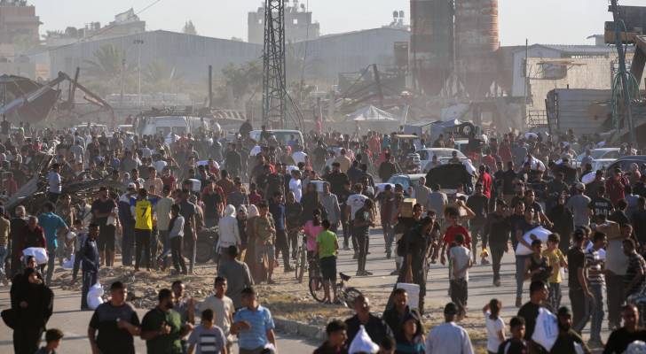نازحون ينقلون أكياسا من المساعدات الغذائية وسط قطاع غزة
