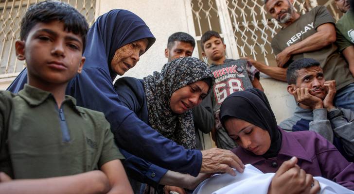 سيدة تحمل طفلها الشهيد في مستشفى الشفاء بمدينة غزة