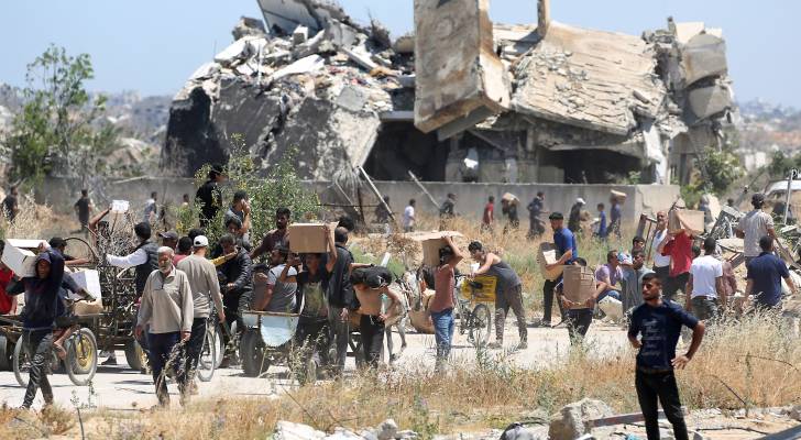 غزيون يحملون صناديق من الإمدادات الإغاثية