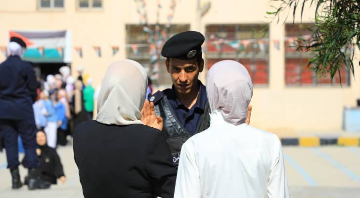 رجل أمن عند بوابة مدرسة قبيل تقديم امتحان التوجيهي