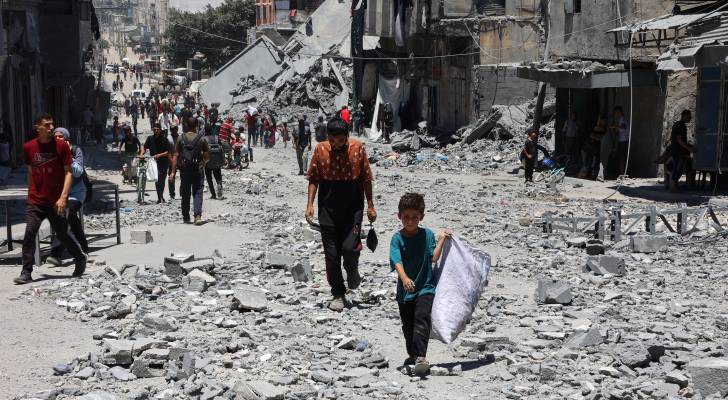 فلسطينيون بين أنقاض المباني التي دمرت في ضربات إسرائيلية على حي الدرج في مدينة غزة