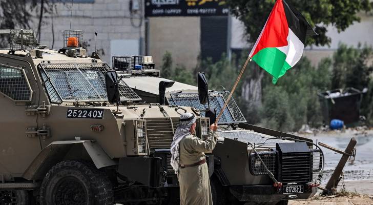 مسن فلسطيني يرفع علم بلاده أمام آليات الاحتلال في الضفة الغربية