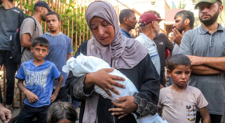 فلسطينية تحمل طفلها الشهيد في غزة