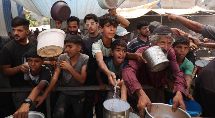 أطفال فلسطينيون يطلبون الغذاء في مخيم النصيرات وسط قطاع غزة