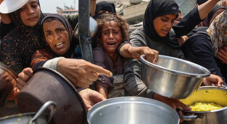 فتاة فلسطينية تبكي بينما تحاول الحصول على وجبات مطهية مع آخرين من مركز توزيع غذاء في مدينة غزة