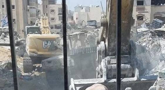 جرافة الاحتلال تجرف جثمان شهيد في جباليا