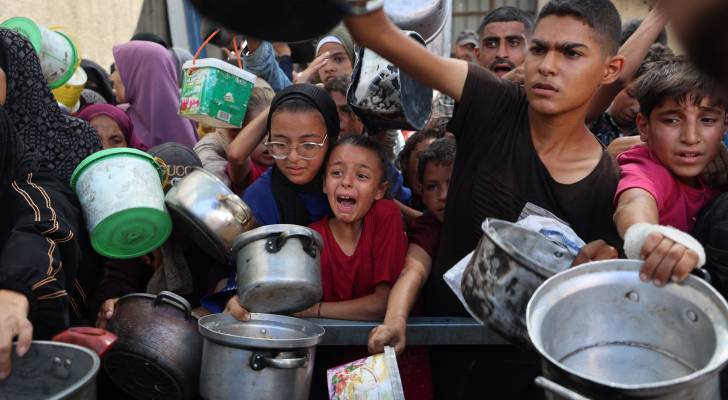 فلسطينيون يتلقون مساعدات غذائية في مخيم النصيرات في غزة