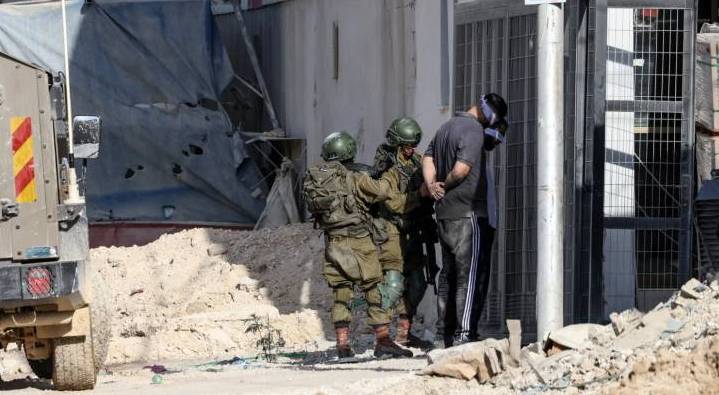 ارشيفية.. جنديان من جيش الاحتلال يقيدان شاب فلسطين في الضفة الغربية