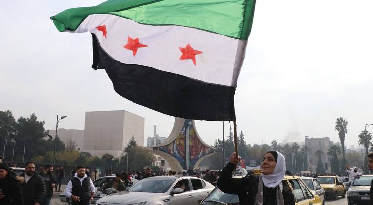 امرأة سورية تحمل العلم السوري